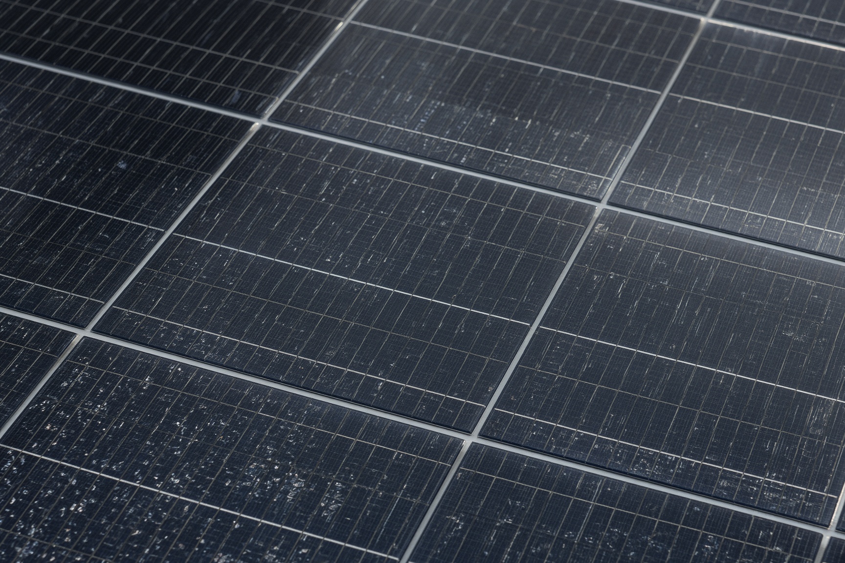 Close up of monocrystalline solar panel cells showing characteristic dark blue colour and grid pattern